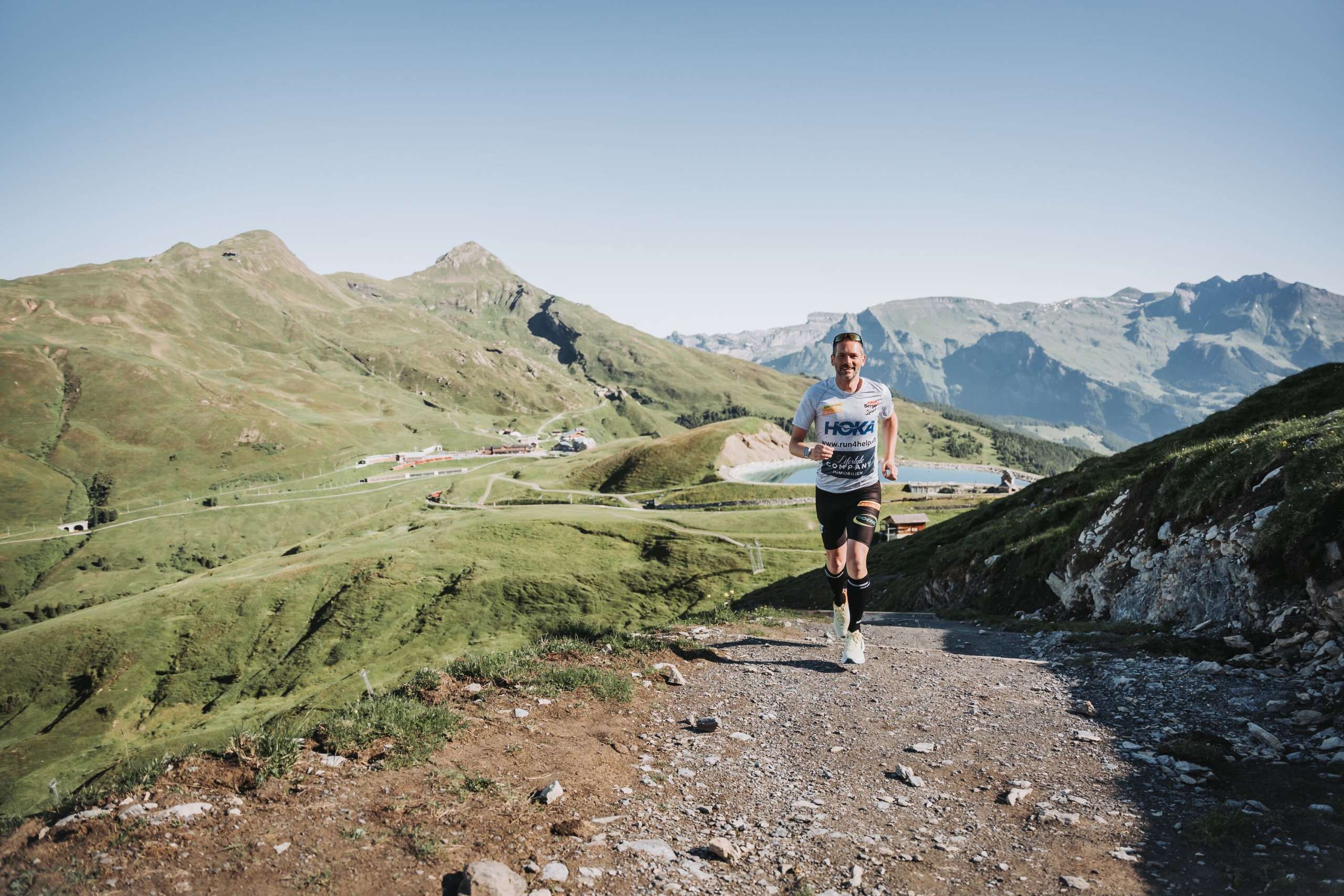 Un coureur sur le parcours de montagne du marathon de la Jungfrau. On aperçoit la Kleine Scheidegg en arrière-plan.