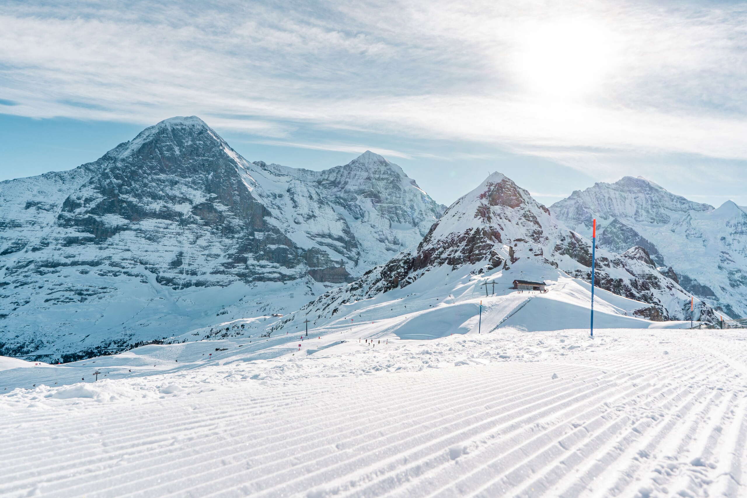 Panoramablick von der Skipiste zum Männlichen und im Hintergrund zeigen sich Eiger, Mönch und Jungfrau im weissen Gewand.