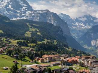 Derrière le village estival de Wengen, on aperçoit la vallée de Lauterbrunnen avec ses falaises abruptes.