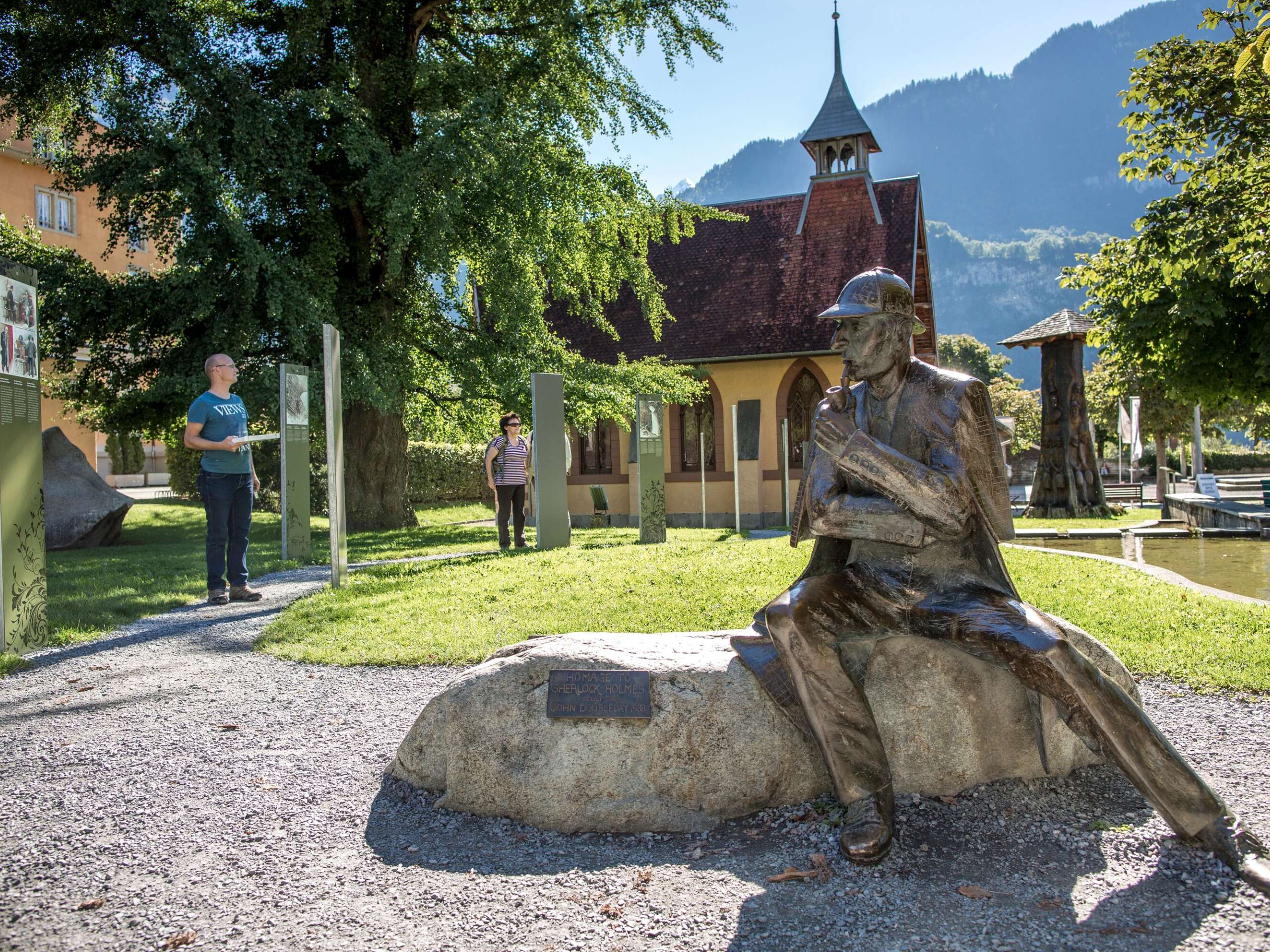 A statue of the master detective stands in front of the Sherlock Holmes Museum in Meiringen. Tourists read up on the history of Sherlock Holmes.