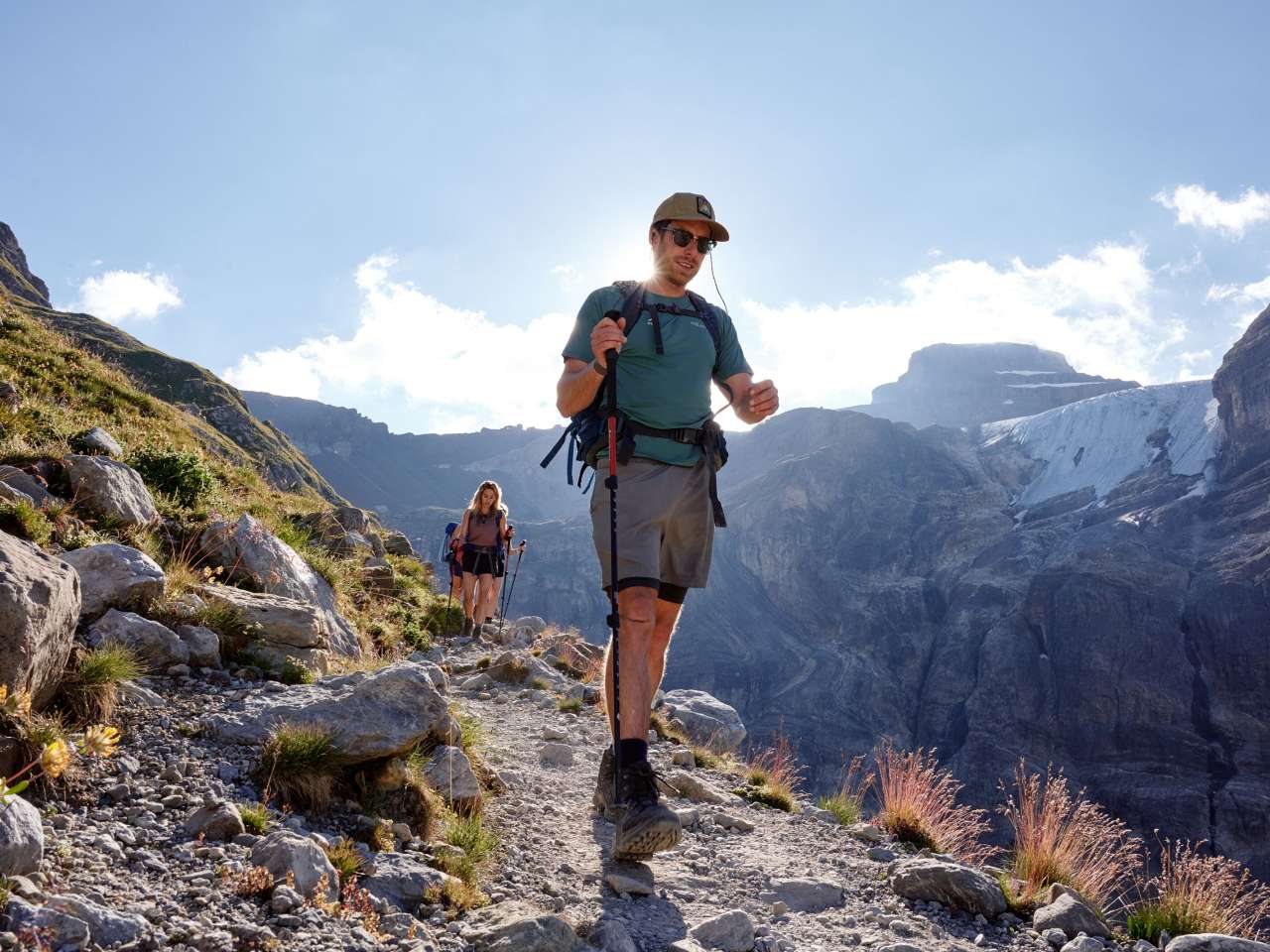 Wanderer*innen unterwegs hoch über dem Lauterbrunnental, inmitten der imposanten Bergwelt.
