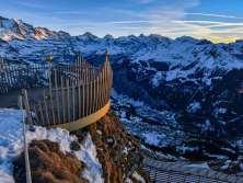 Die Krone vom Royal Walk wird von der untergehenden Sonne beleuchet. Das verschneite Bergpanorama im Hintergrund verleiht der Region rund um Wengen eine magische Stimmung.