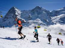 Teilnehmer im Ziel des Lauberhorn Runs mit direktem Blick auf das weltberühmte Dreigestirn.