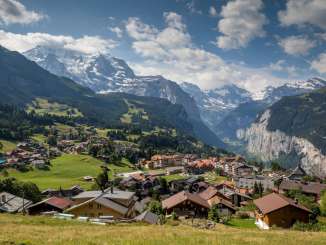 Hinter dem sommerlichen Dorf Wengen sieht man das Lauterbrunnental mit den steilen Felsen.