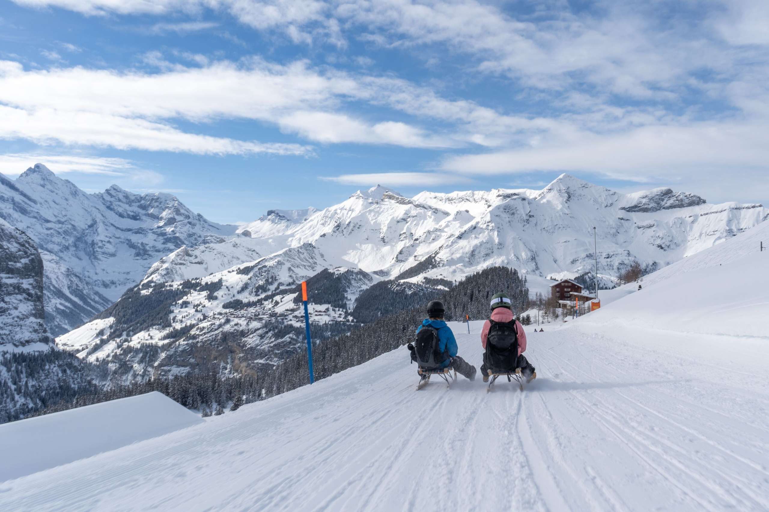 Fast-paced toboggan run on the Fox Run on the Männlichen. The white mountain panorama stretches out in the background.