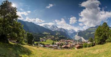 Derrière le village estival de Wengen, on aperçoit la vallée de Lauterbrunnen avec ses falaises abruptes.