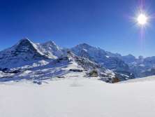 Un paysage hivernal à couper le souffle au Männlichen. La vue dévoile le trio de l'Eiger, du Mönch et de la Jungfrau sous son plus beau jour.