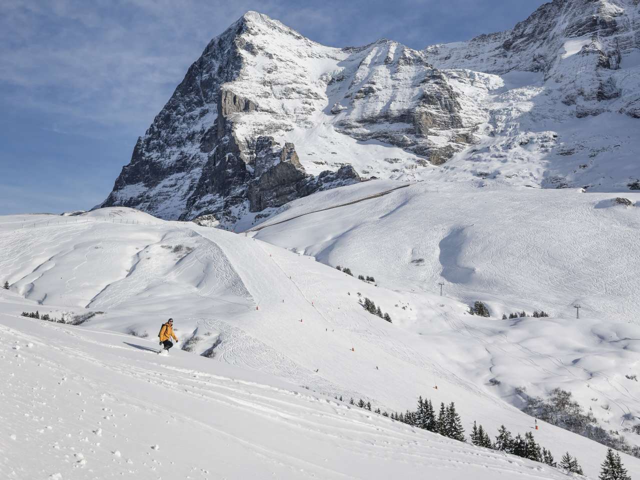 Wanderung durch den Schnee auf der Kleinen Scheidegg. Im Hintergrund türmt der Eiger im Schnee bedecktem Gewand.